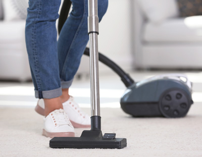Maid service vacuuming carpet
