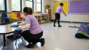 Classroom and daycare cleaning in Northern Kentucky - Jeannie’s Cleaning Company - Jeannie’s Cleaning Company Two cleaners in purple shirts wipe tables and mop the floor in a classroom