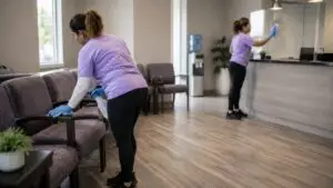 Medical office waiting room cleaning in Northern Kentucky - Jeannie’s Cleaning Company - Jeannie’s Cleaning Company Two cleaners disinfect waiting room chairs and reception glass in a medical office